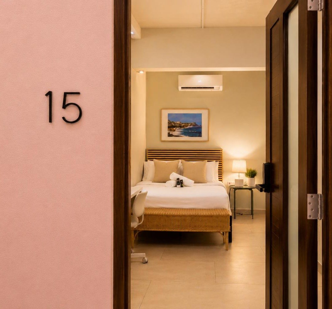 The signature pink doorway of a Hotel Luz guest room